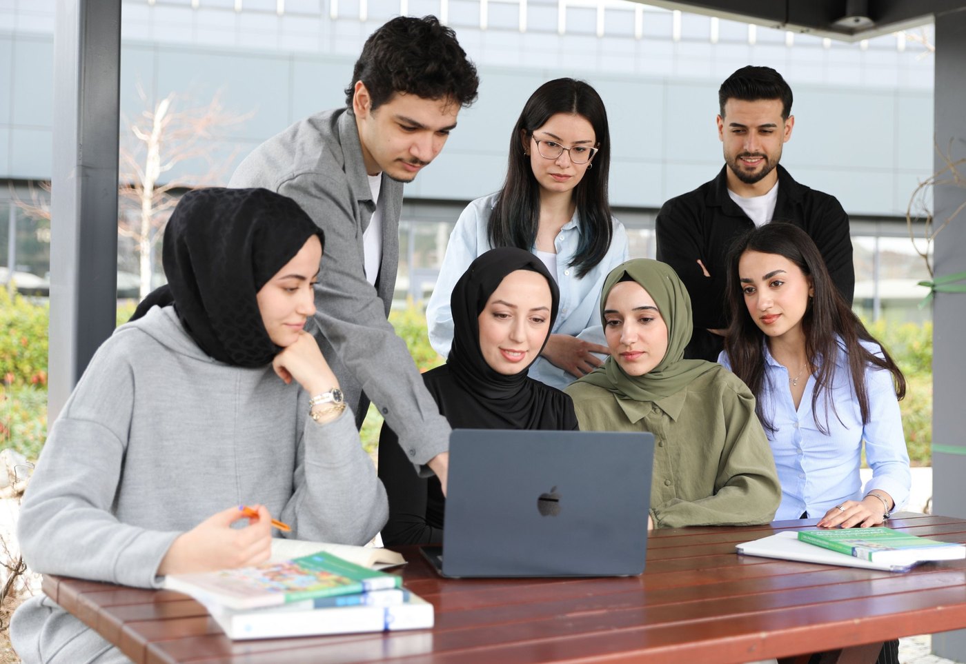 A group of healthcare learners studying together around a laptop